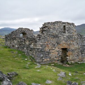Stone ruins of the medieval Norse Hvalsey Church overlooking a fjord in South Greenland