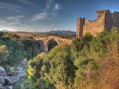 Castello della Badia and the ancient Abbadia bridge over the Fiora River gorge at Vulci, Italy
