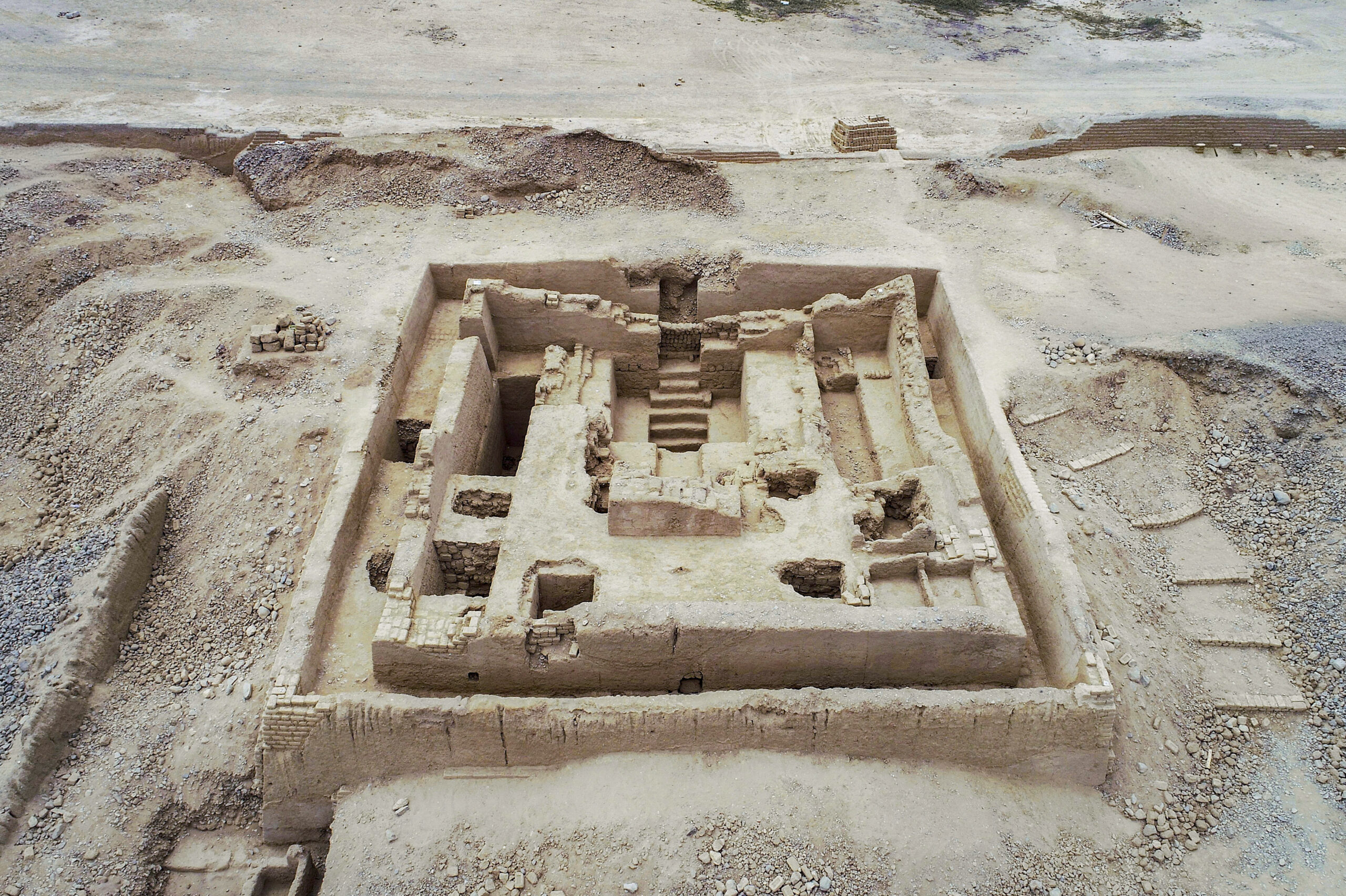 Aerial view of the excavated square adobe funerary platform at Chan Chan’s Utzh An complex, showing chambers and a central staircase